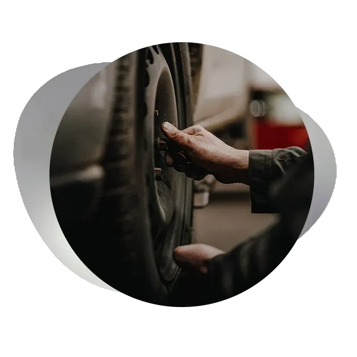 Reifenwechsel: Hand eines Mechanikers beim Wechseln eines Autoreifens