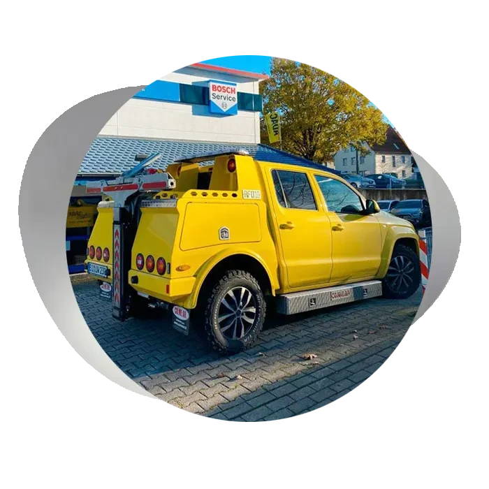 Gelbes Abschleppfahrzeug vor einer Bosch Service Werkstatt