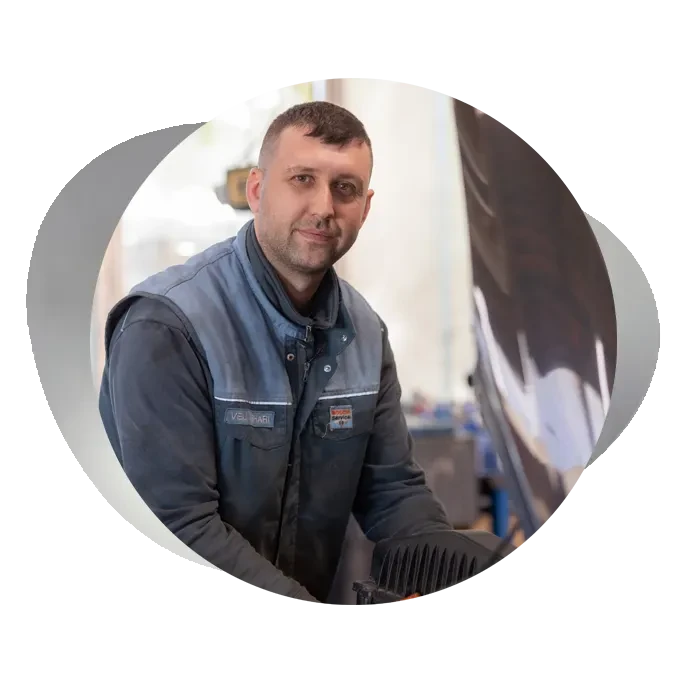 Mitarbeiter in Arbeitskleidung in einer Werkstatt – Startseite rundes Bild