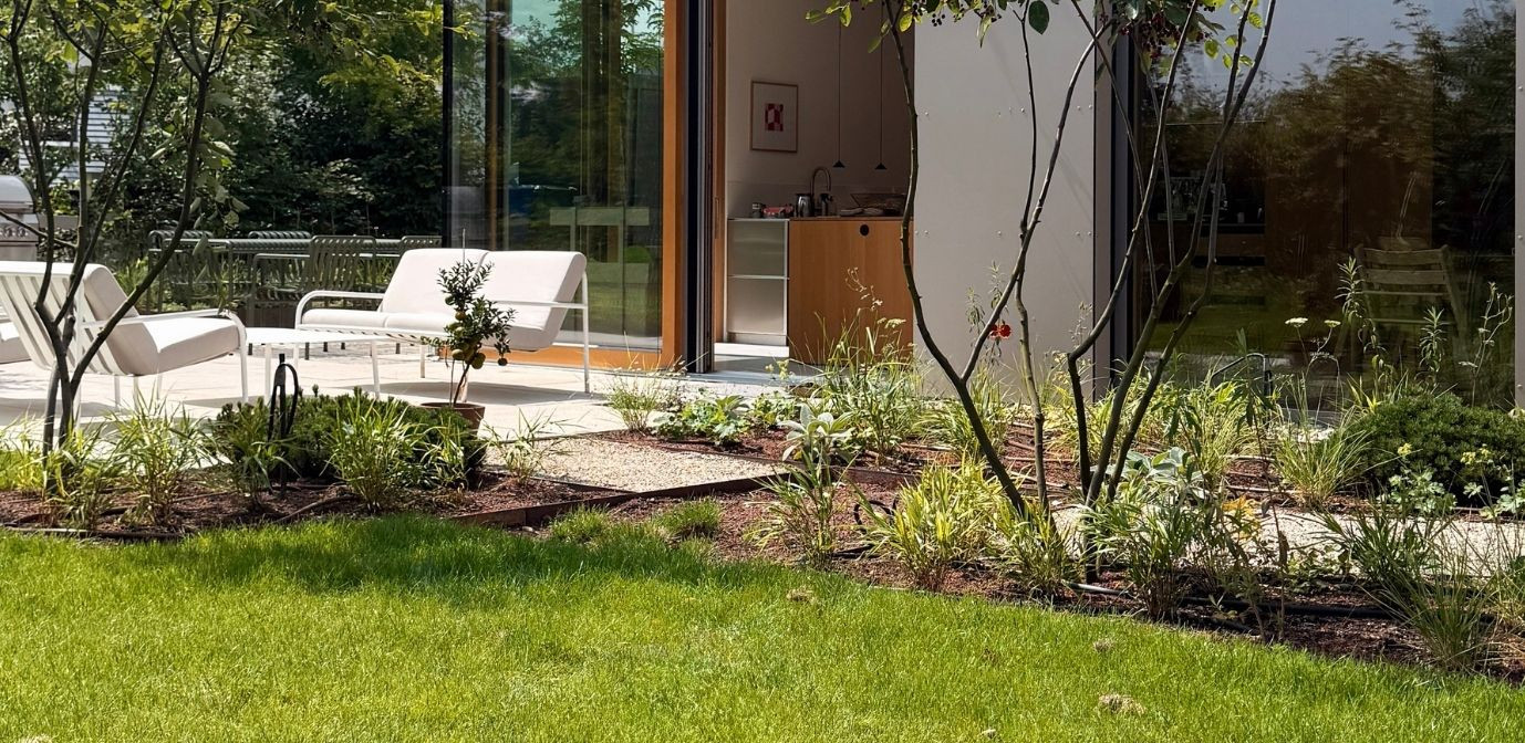 Modernes Gartenbau-Projekt in Karlsruhe mit Terrasse und Bepflanzung vor einem offenen Wohnbereich