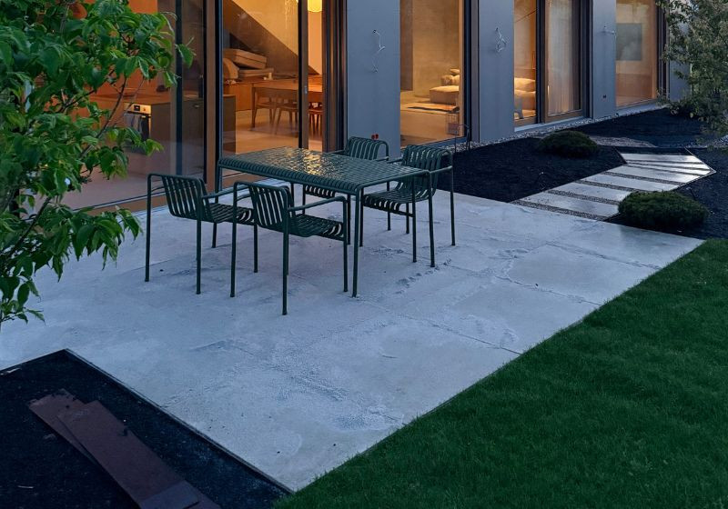 Moderne Terrasse nach dem Bau in Karlsruhe mit Gartenmöbeln und Blick ins Wohnzimmer