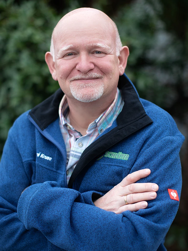 André Kruse mit blauer Schlüter-Jacke, verschränkte Arme