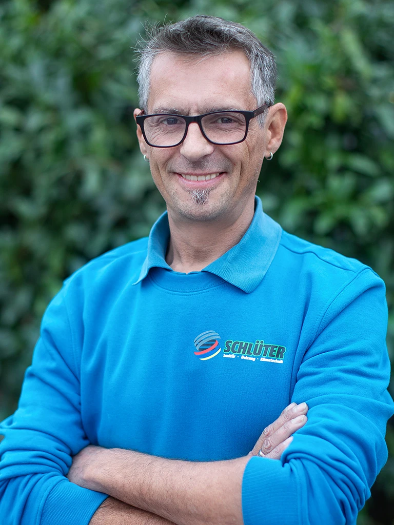 Stefan Rosner im blauen Schlüter Pullover vor grüner Natur