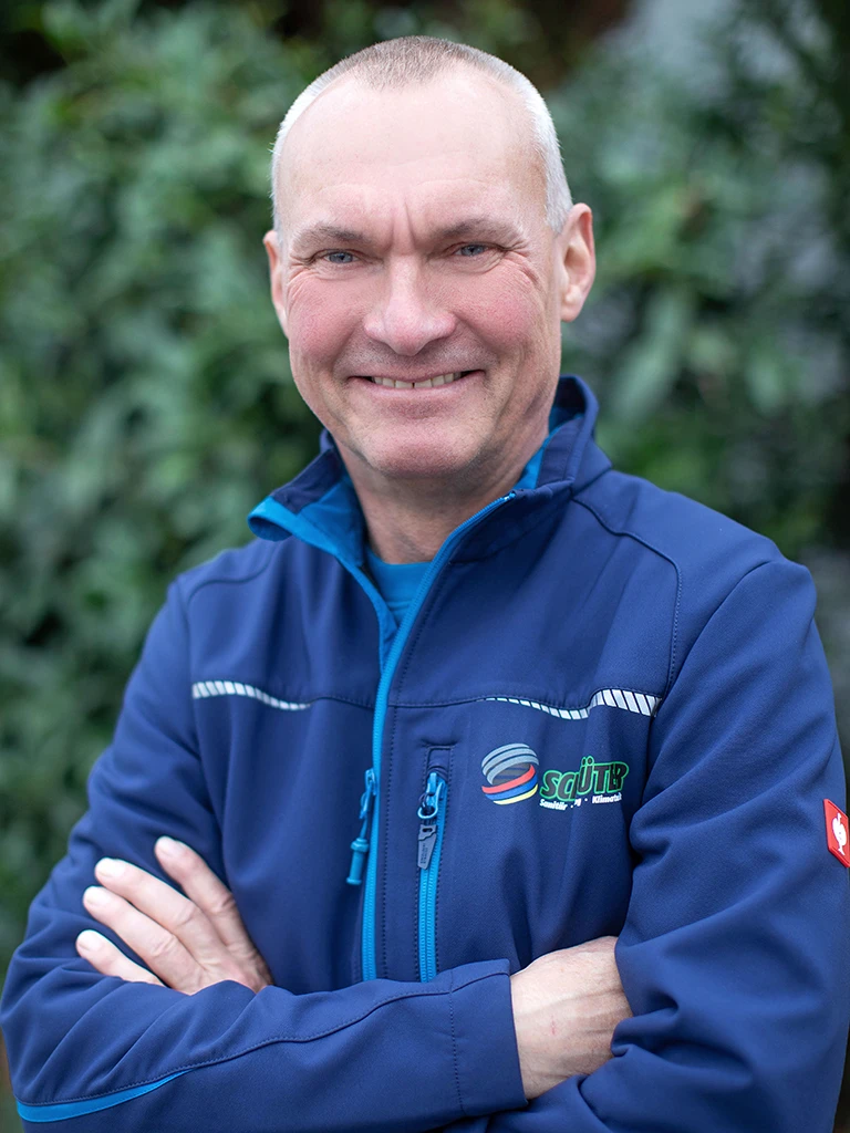 Detlev Steinmann mit blauer SQUiR-Jacke vor grüner Naturkulisse
