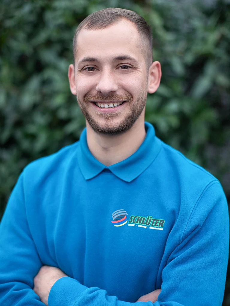 Dragos Gherman im Schlüter Arbeitsoutfit vor grüner Naturkulisse