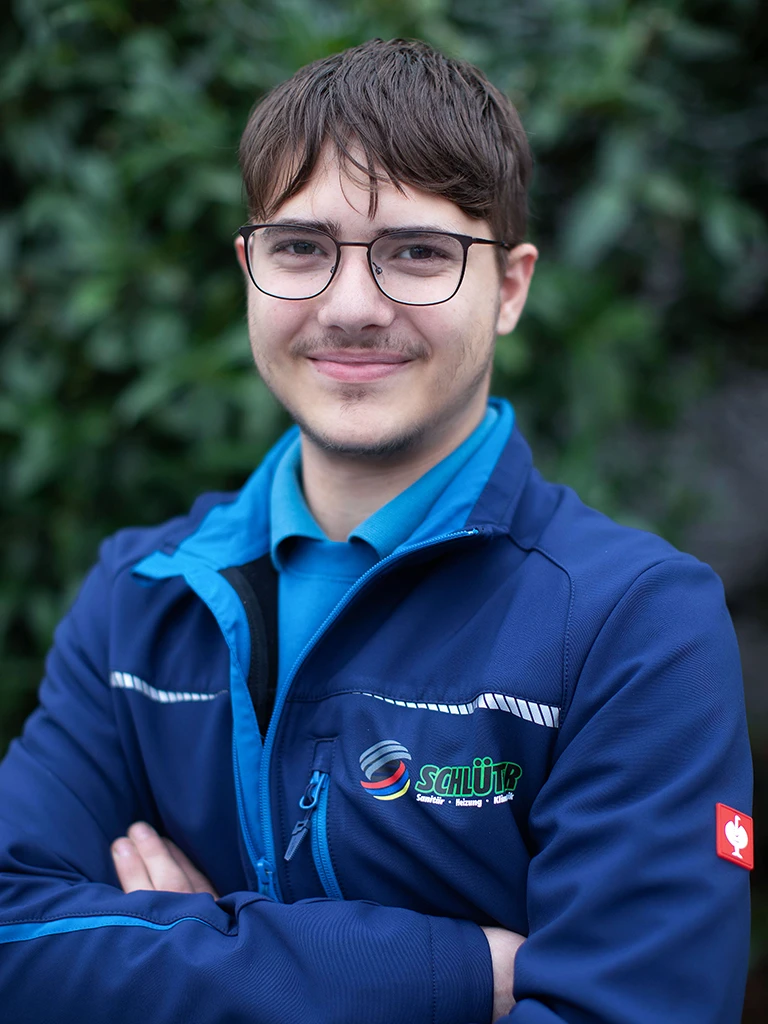 Finn Mathemeier im Schlüter Arbeitsoutfit vor unscharfem Hintergrund