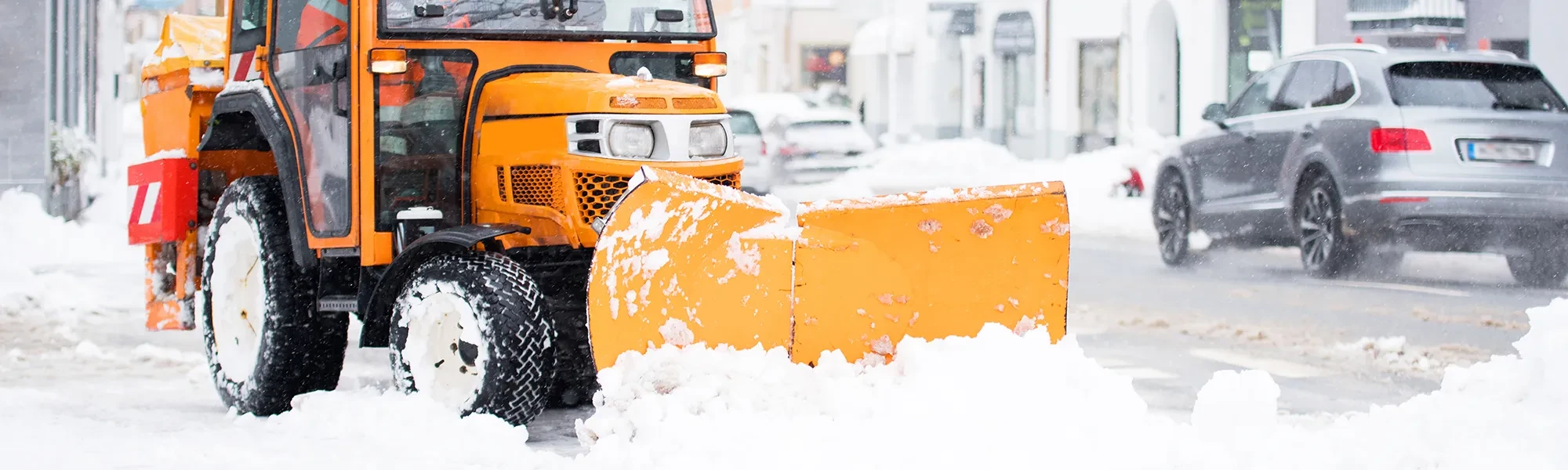 Winterdienst im Einsatz mit Schneepflug auf verschneiter Straße