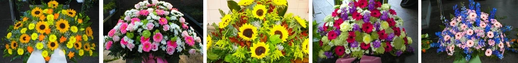 Trauergestecke mit Sonnenblumen und grünem Beiwerk als Blumenschmuck für Beerdigungen