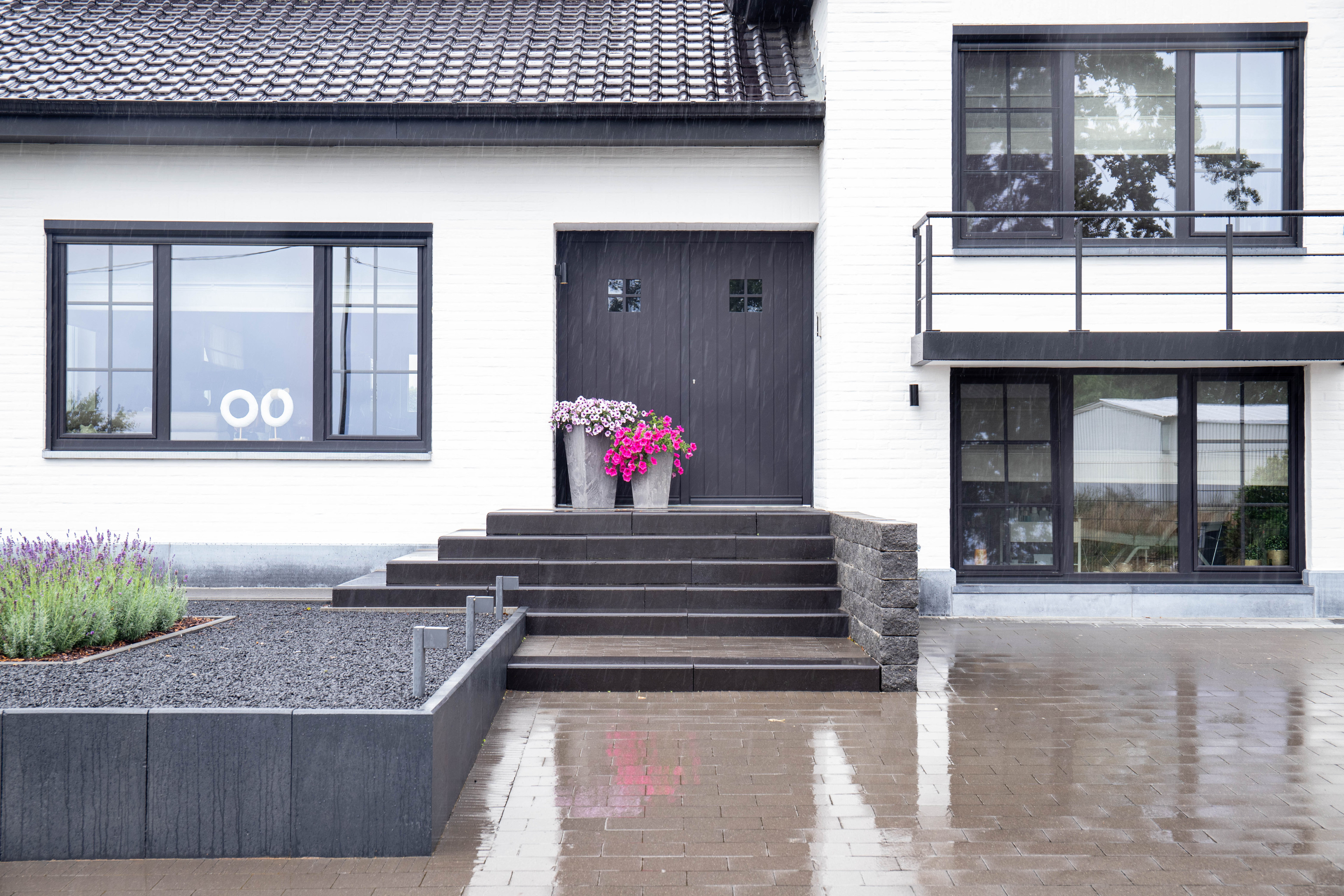 Moderne Hauseingangstreppe mit Blumentöpfen vor dem Gebäude Gorissen44 bei Regen