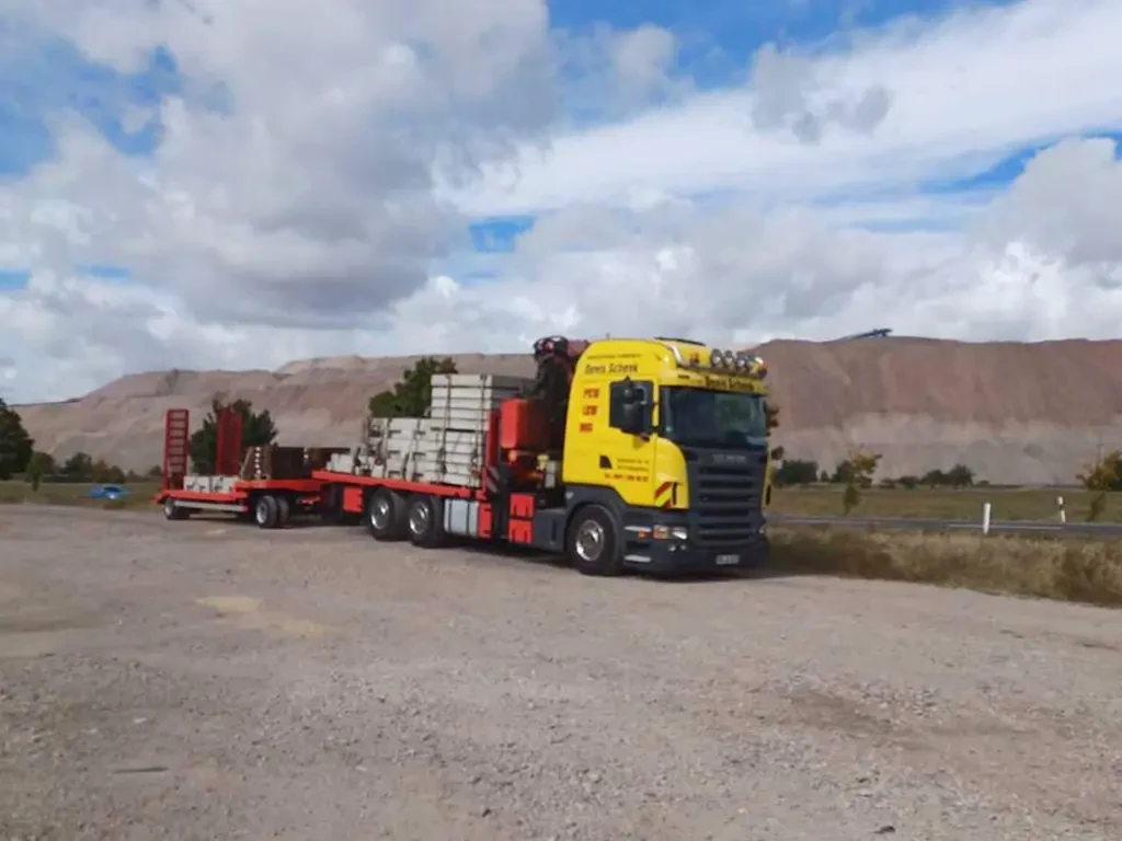 LKW für Logistik und Transport auf einem Schotterplatz vor einer Hügellandschaft