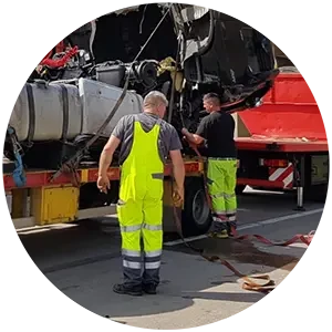 Abtransport eines beschädigten Fahrzeugs durch Arbeiter auf einem Abschleppwagen