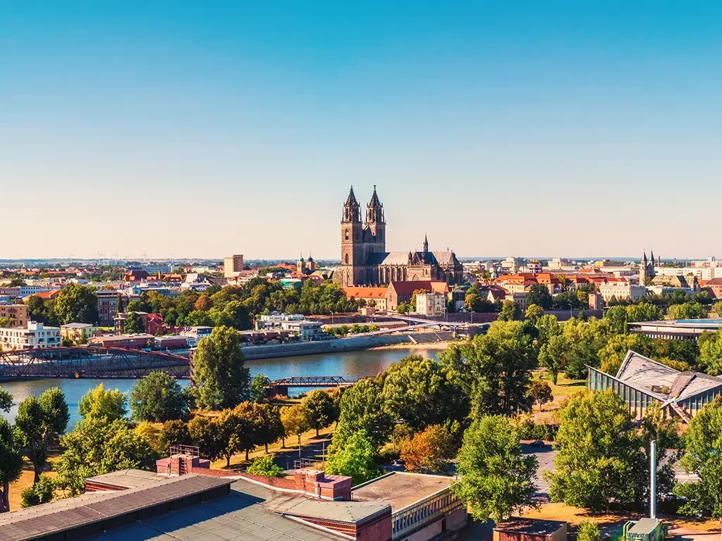 Panorama einer Stadt mit Dom und Fluss, symbolisch für verschiedene Standorte