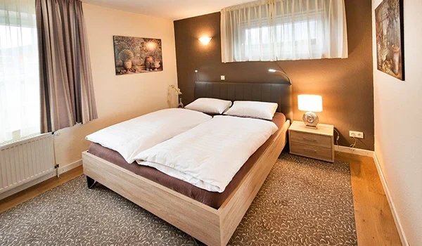 Gemütliches modernes Zimmer mit Doppelbett und stilvoller Einrichtung als Teaserbild