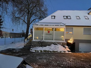 Gebäude des Deutschen Roten Kreuzes im Winter mit Schnee und Weihnachtsbeleuchtung