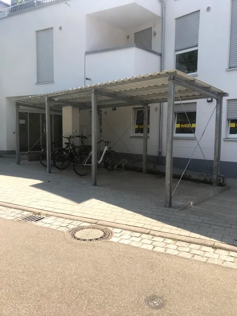 Fahrradüberdachung vor einem Gebäude mit mehreren Fahrrädern