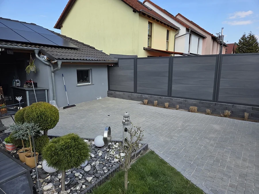 Moderne Hofgestaltung von CW Partnerputz – Referenzprojekt mit Pflastersteinen, Sichtschutz und gepflegtem Garten