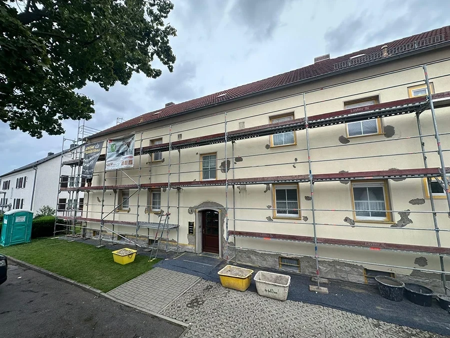 Fassadensanierung eines Wohnhauses durch CW Partnerputz, Referenzprojekt mit Baugerüst und Baumaterialien