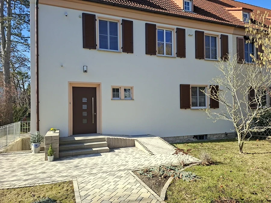 Fassadensanierung Referenz von CW Partnerputz – renoviertes Wohnhaus mit neuem Putz und moderner Eingangsgestaltung