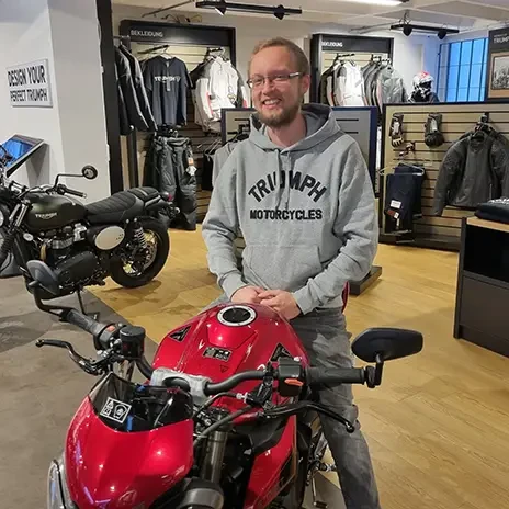 Florian Stara mit Triumph Motorrad in einem Triumph Showroom