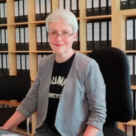 Natalija Horvath im Büro vor einem Regal mit Aktenordnern