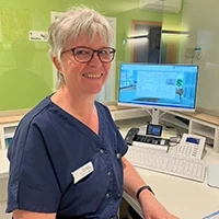 Birgit Gierspeck am Empfangsschalter in einer medizinischen Einrichtung