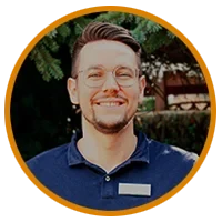 Teammitglied Carl Max im Firmenoutfit vor grünem Hintergrund