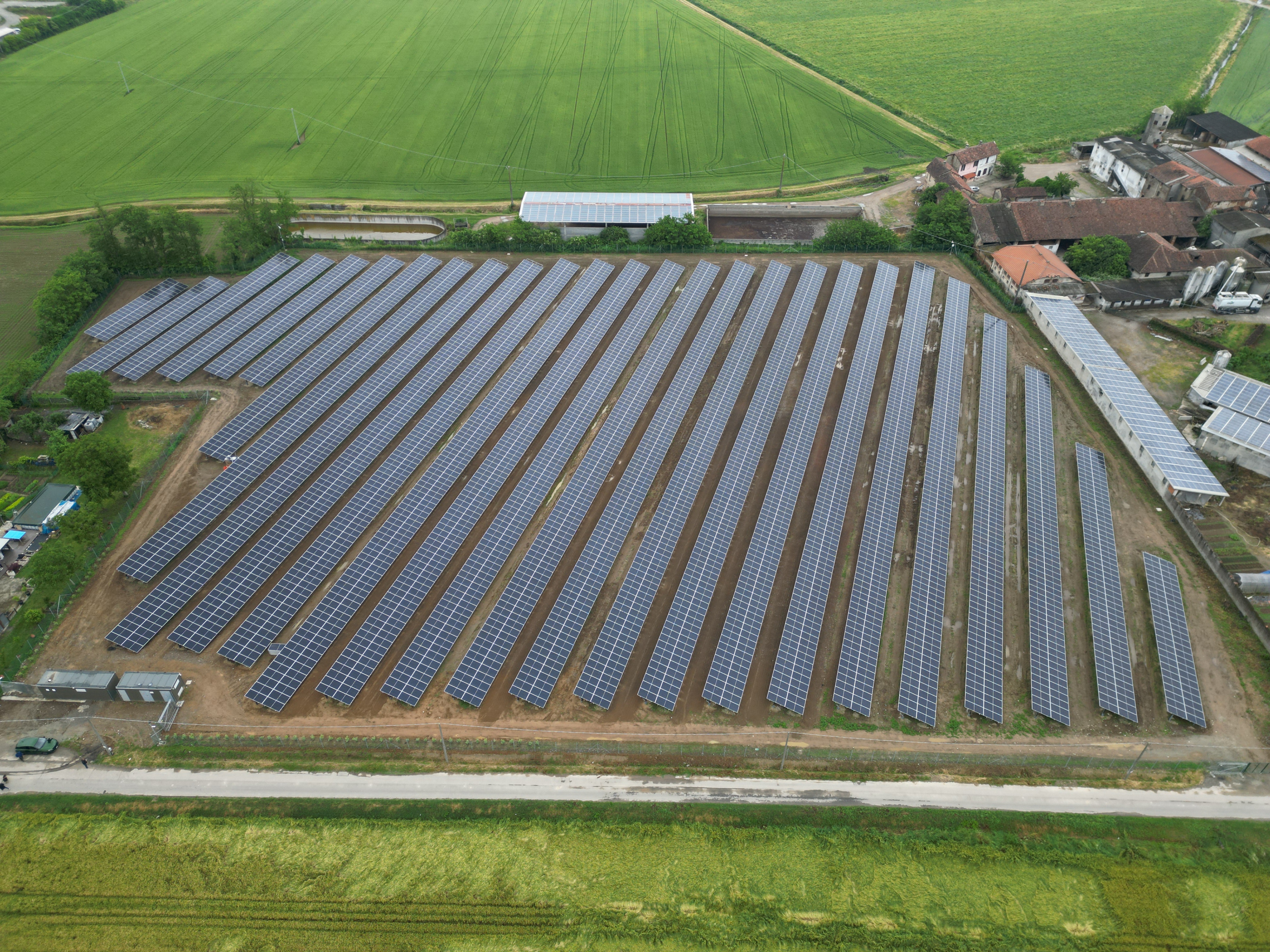 Drohnenfoto einer großen Solaranlage auf einem Feld im Sommer