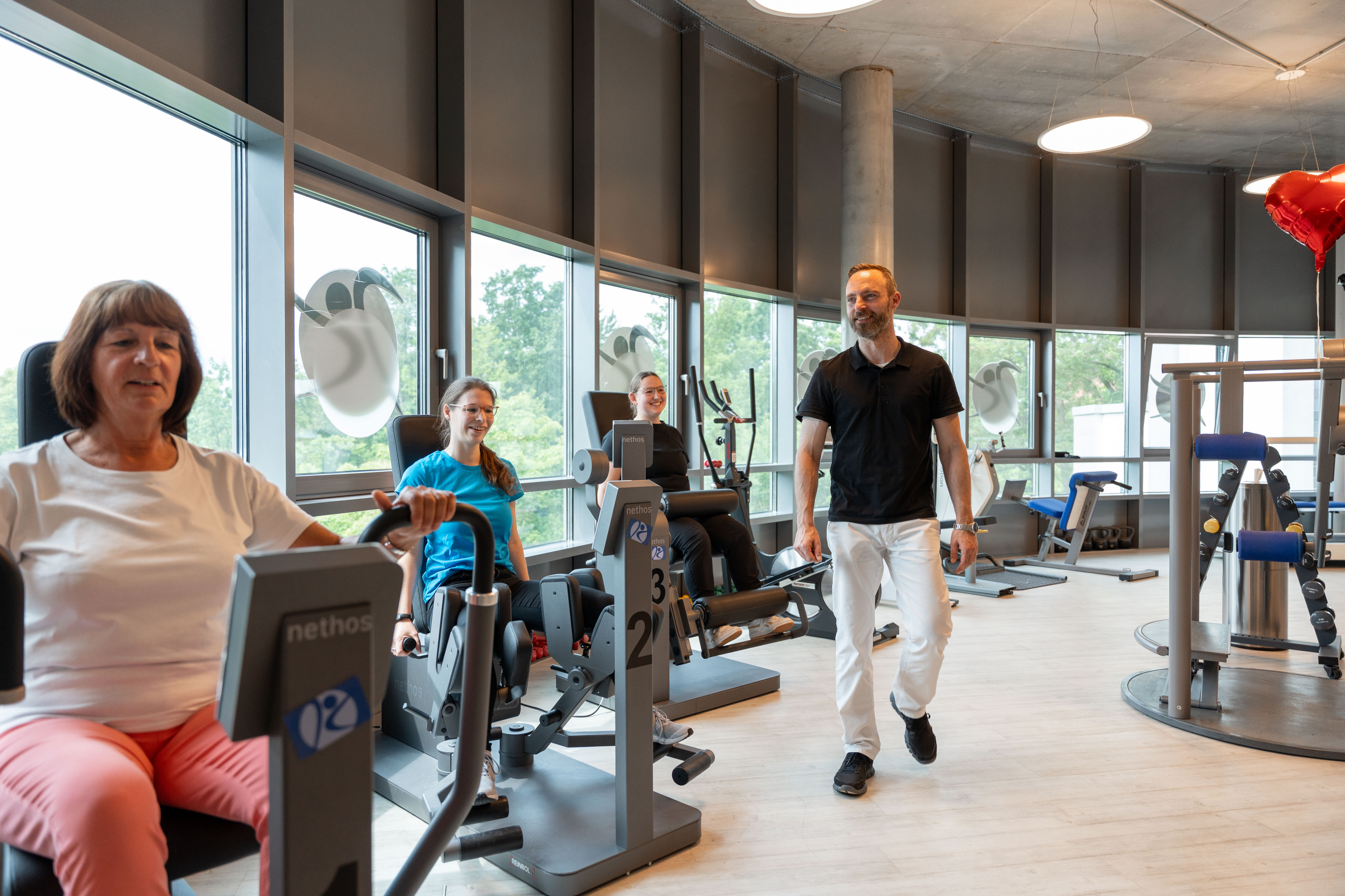 Trainingsraum in der Praxis für Physiotherapie Kemper mit modernen Fitnessgeräten und Patienten beim Training