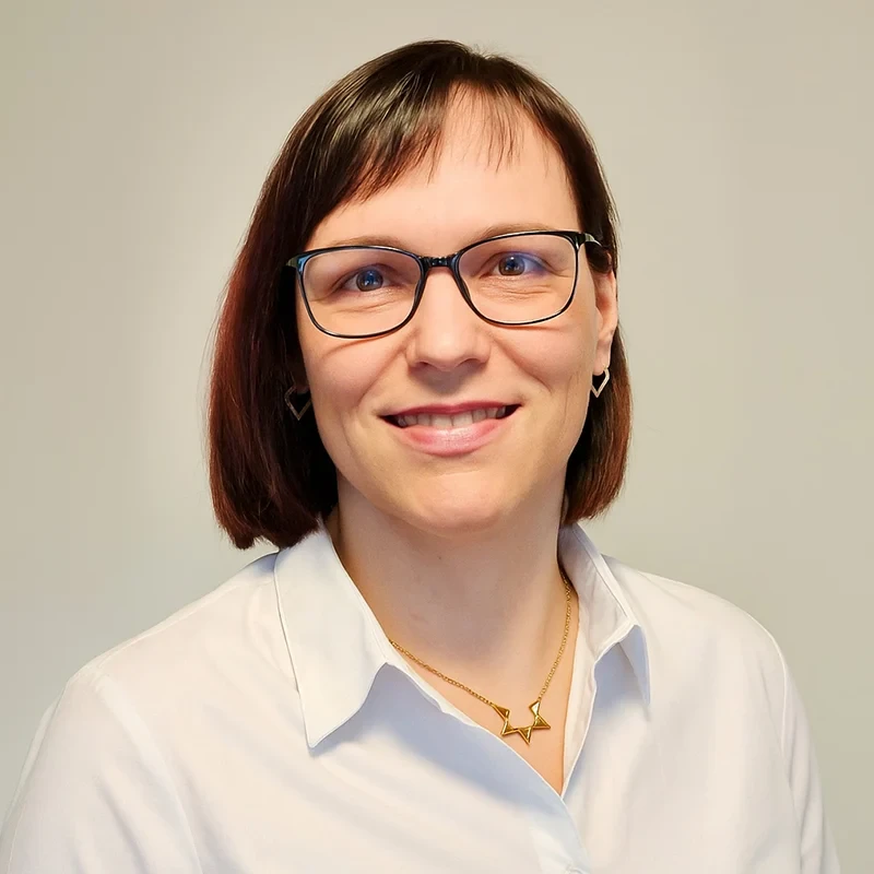 Portrait von Melanie mit weißer Bluse und goldener Kette