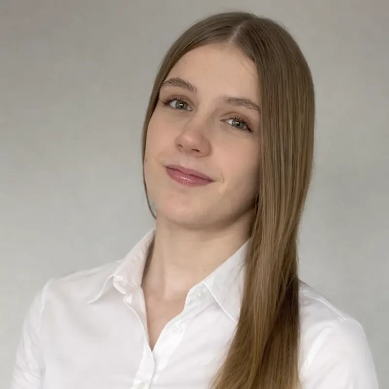 Porträt einer Frau mit langen, glatten, blonden Haaren und weißer Bluse