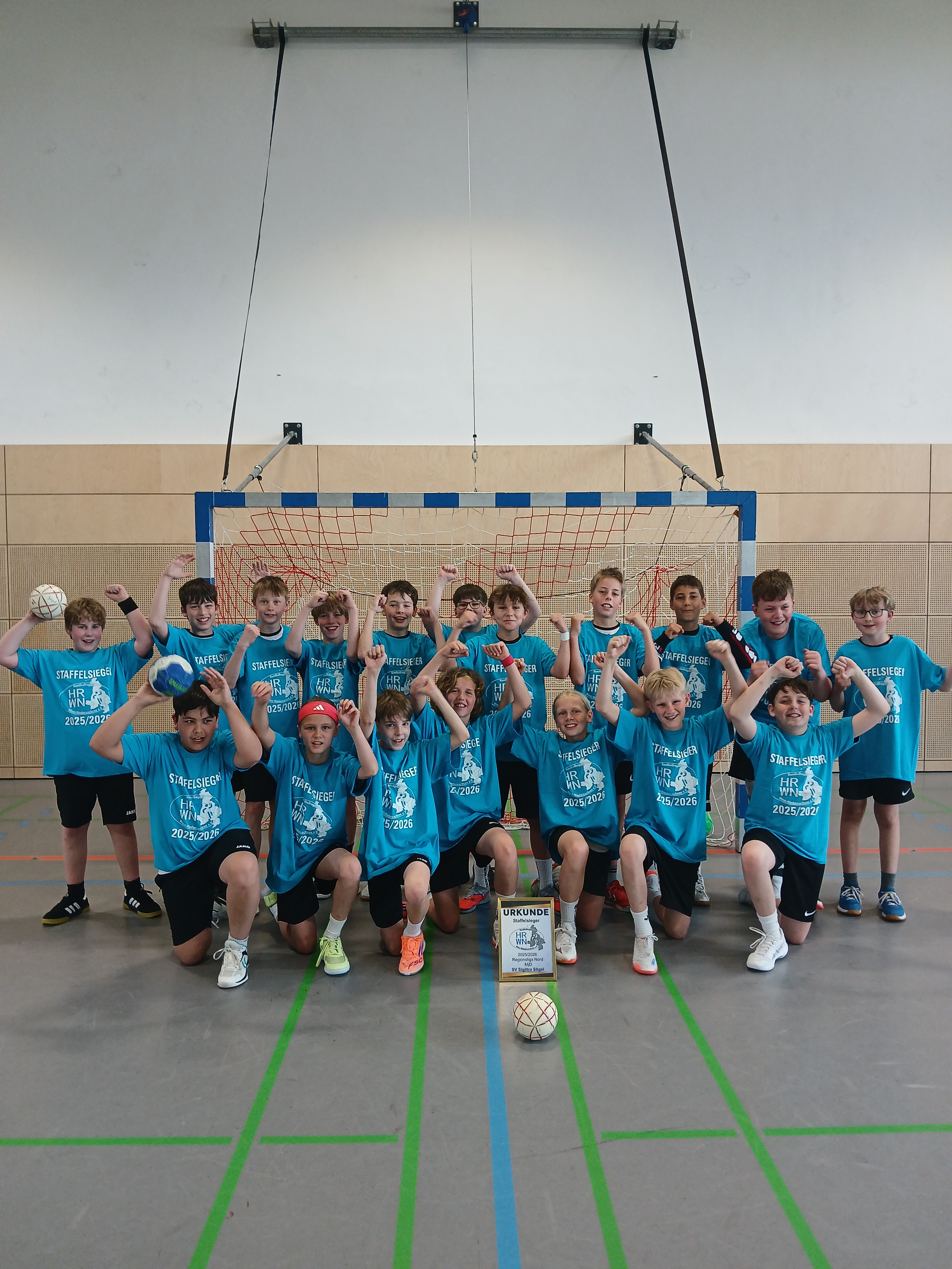 SV Sigiltra Sögel Staffelsieger MJD Handballmannschaft 2023/2024 jubelt in der Sporthalle vor dem Tor mit Urkunde