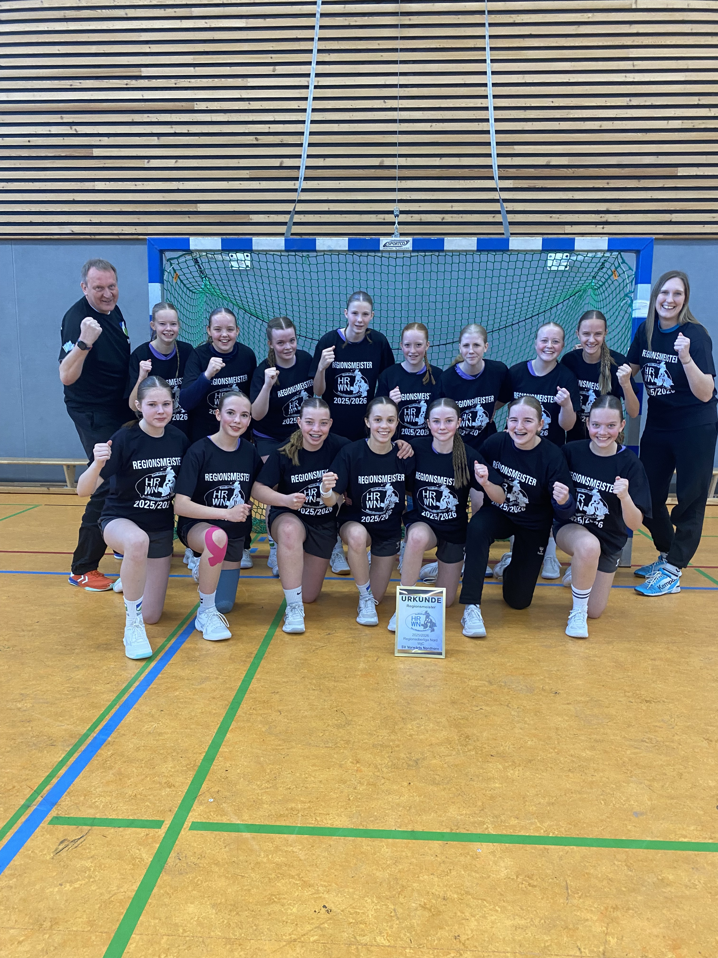 Handballteam der weiblichen Jugend C des Vorwärts Nordhorn nach Gewinn der Regionsmeisterschaft 2025/2026 in der Sporthalle vor dem Tor