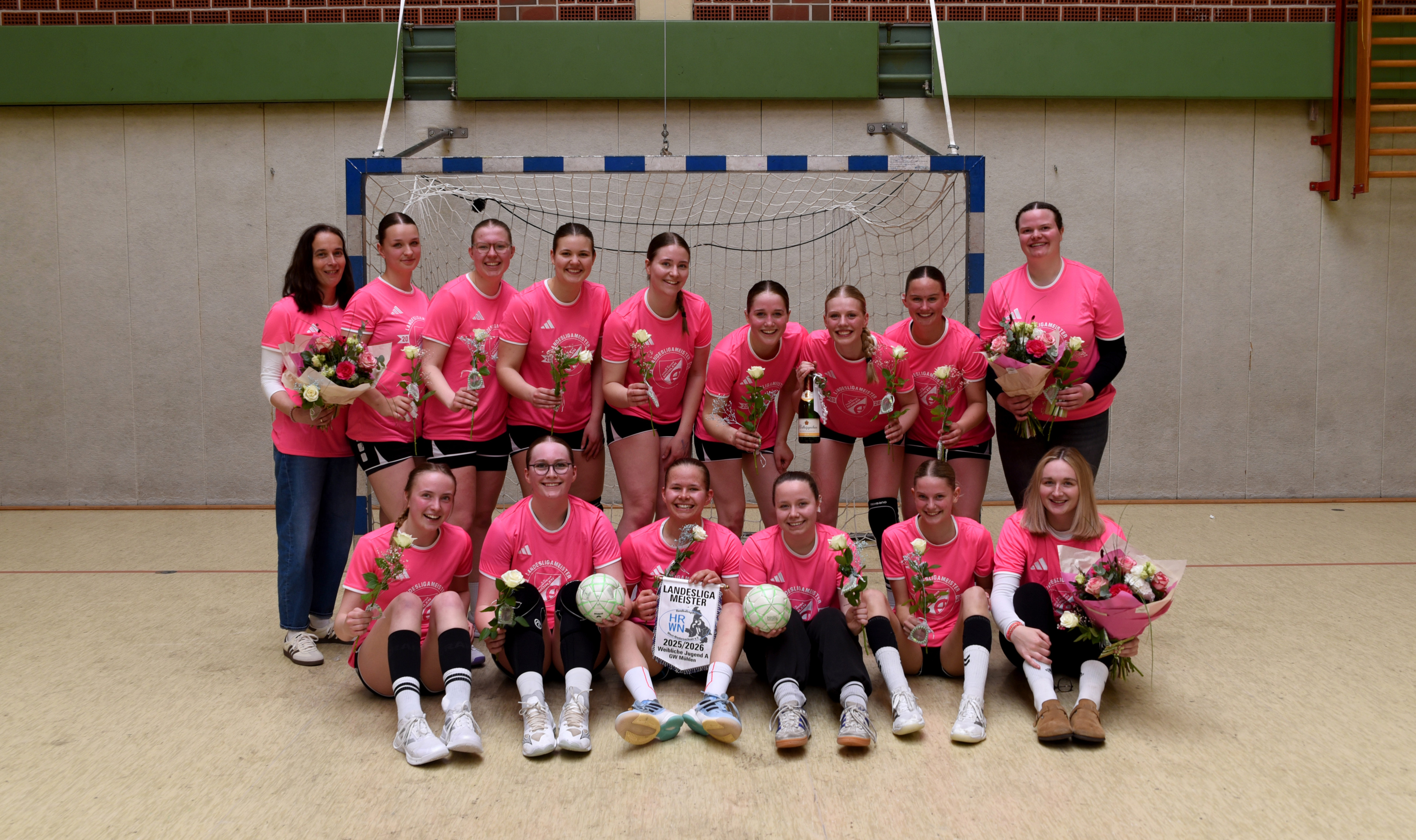 Gruppenfoto der Damen-Handballmannschaft von GW Mühlen als Landesliga-Meister mit Blumen und Pokal