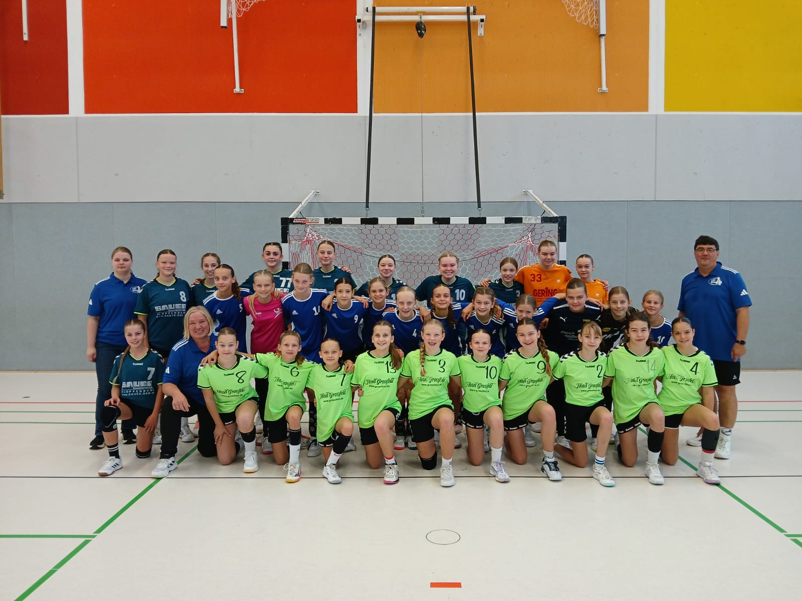 Gruppenfoto eines weiblichen Handballteams Jahrgang 2014 in der Sporthalle vor dem Tor