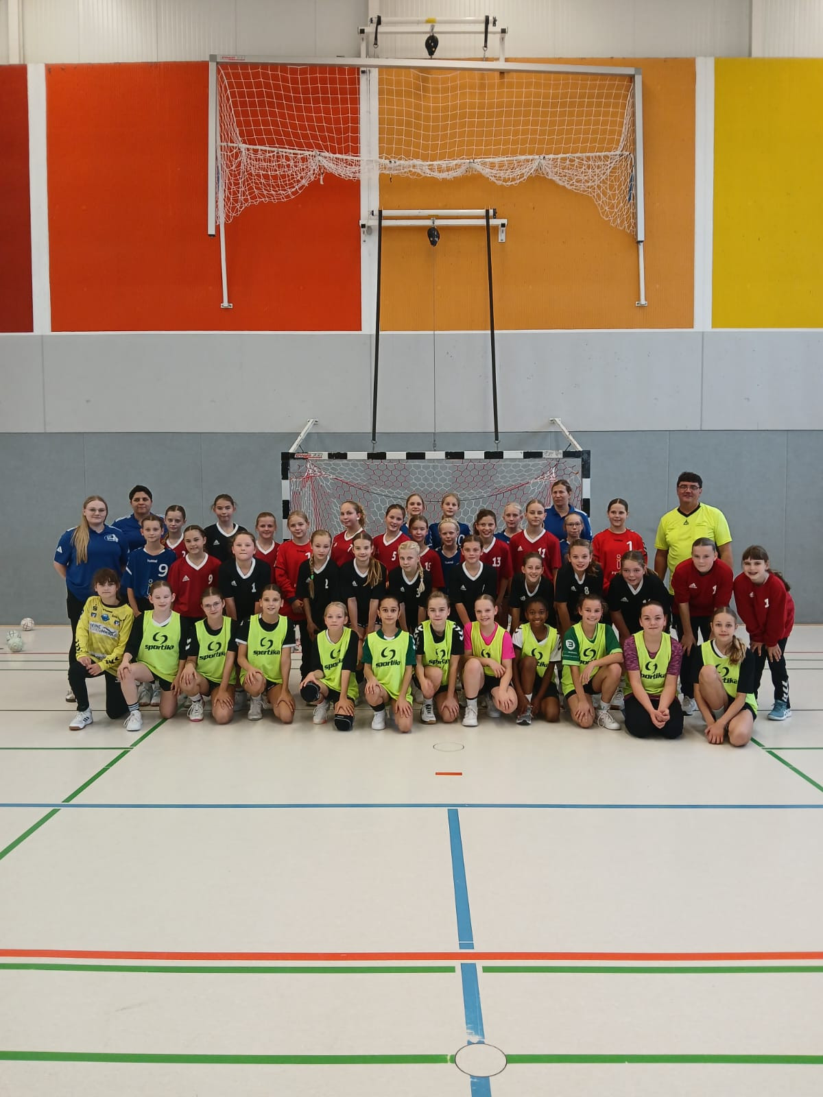 Gruppenfoto eines weiblichen Handballteams Jahrgang 2015 in einer Sporthalle