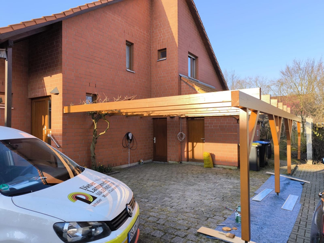 Holz-Carport Installation vor einem roten Backsteinhaus