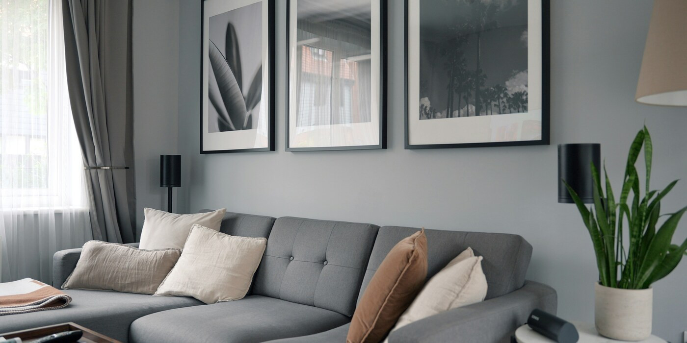 Graue Wand im Wohnzimmer mit moderner Couch und Wandbildern