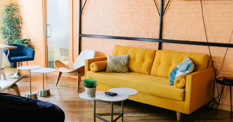 Modernes Wohnzimmer mit orangefarbener Wand und gelbem Sofa