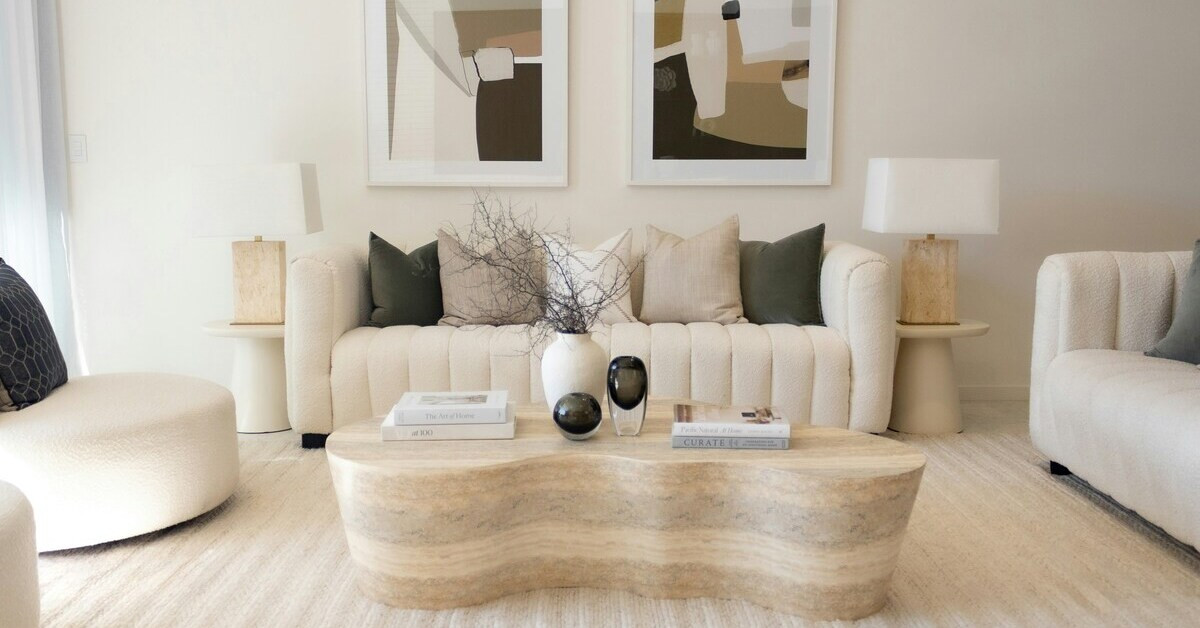 Modernes Wohnzimmer in Beige mit gemütlichem Sofa, abstrakter Wandkunst und Naturdeko