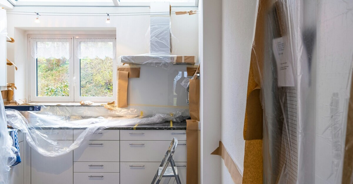 Küche beim Renovieren vor dem Umzug, Möbel und Geräte mit Folie und Papier abgedeckt