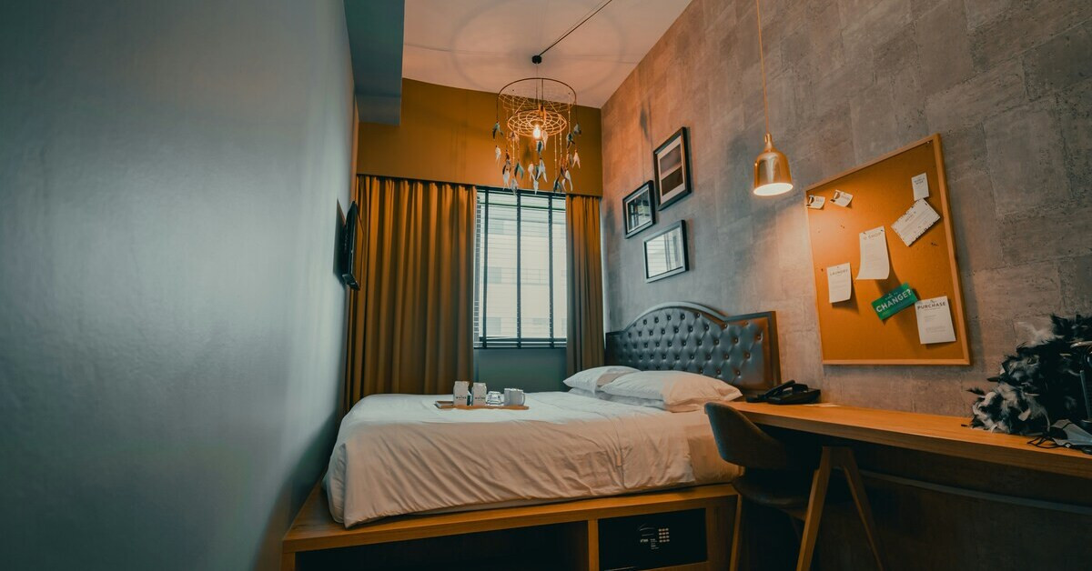 Kleines Zimmer mit modernem Bett, Schreibtisch und gemütlicher Beleuchtung