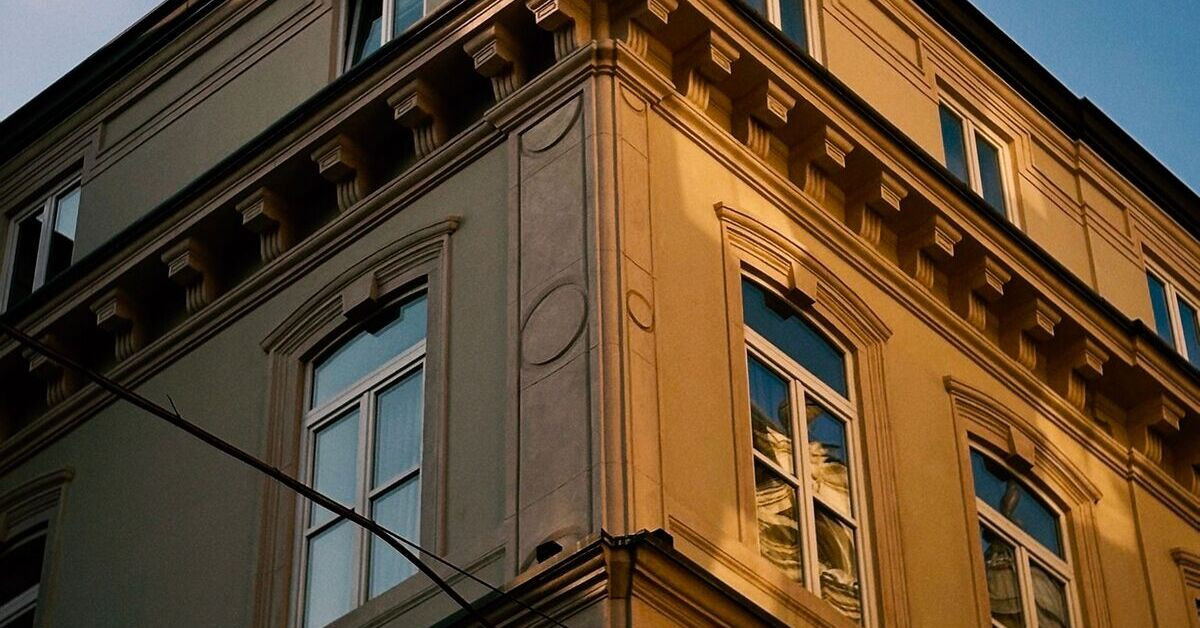Fassade eines Altbaus mit klassischen Stilelementen und großen Fenstern