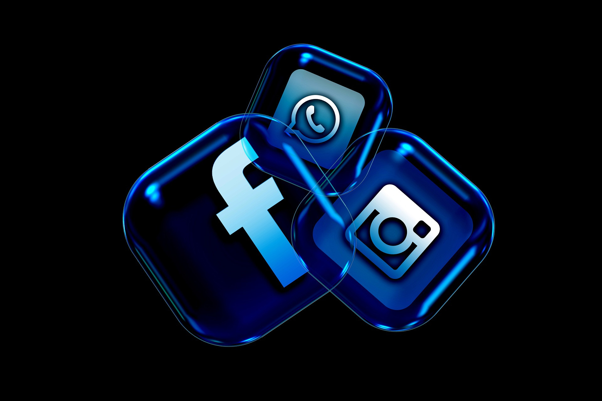 Blaue Social Media Icons von Facebook, Instagram und WhatsApp auf schwarzem Hintergrund