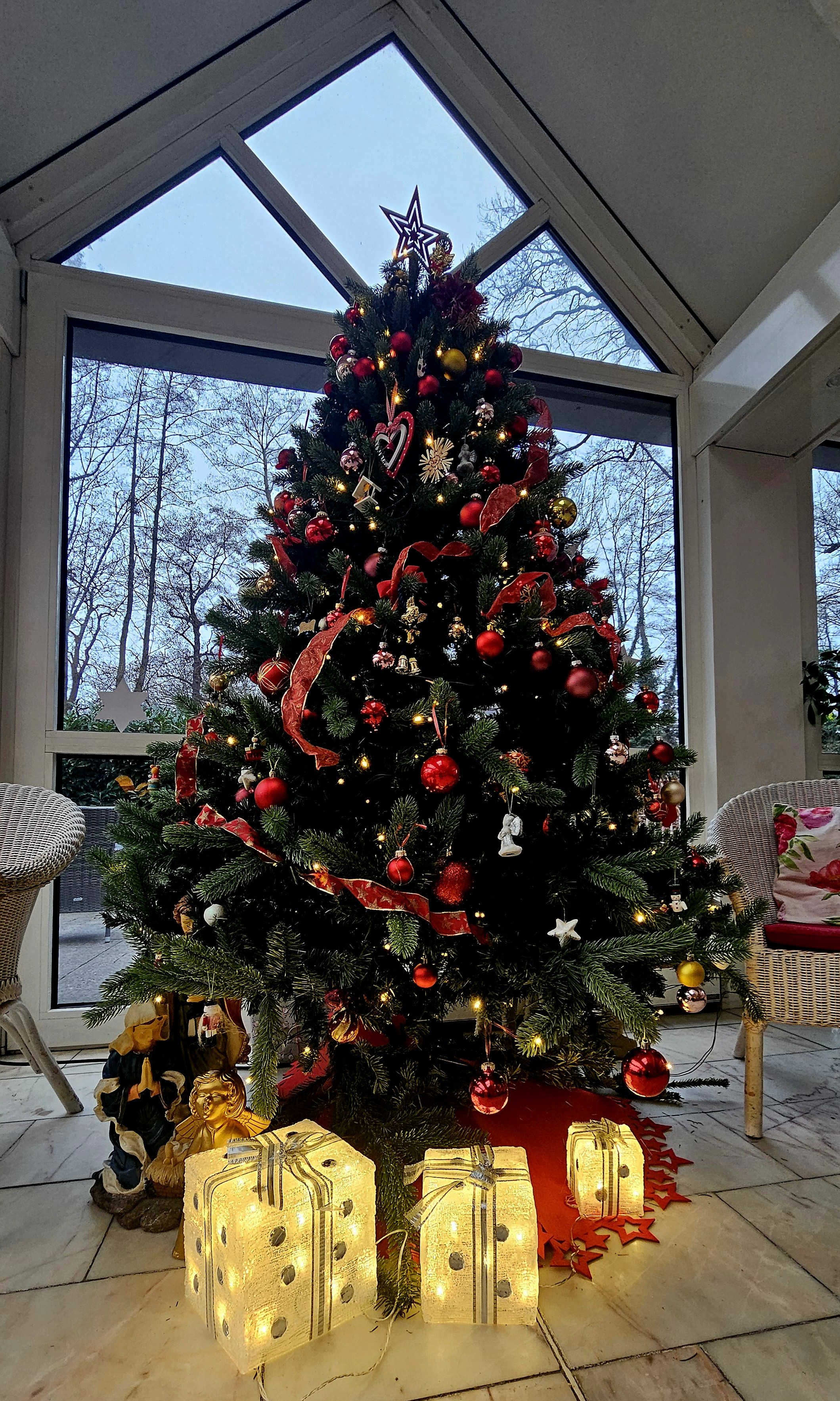 Weihnachtsbaum mit roter und goldener Dekoration in einem Wintergarten am 22. Dezember 2025