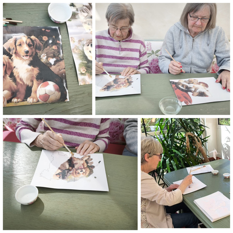Seniorinnen malen Hundebild mit Wasserfarben bei einer kreativen Freizeitbeschäftigung