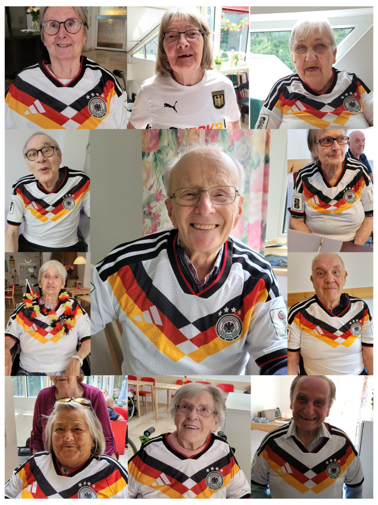 Gruppenfoto mit Senioren in Deutschland-Trikots beim Fußball-Event Mehrere Personen in Deutschland-Trikots feiern Fußball-Event, Gruppenfoto mit Fanartikeln