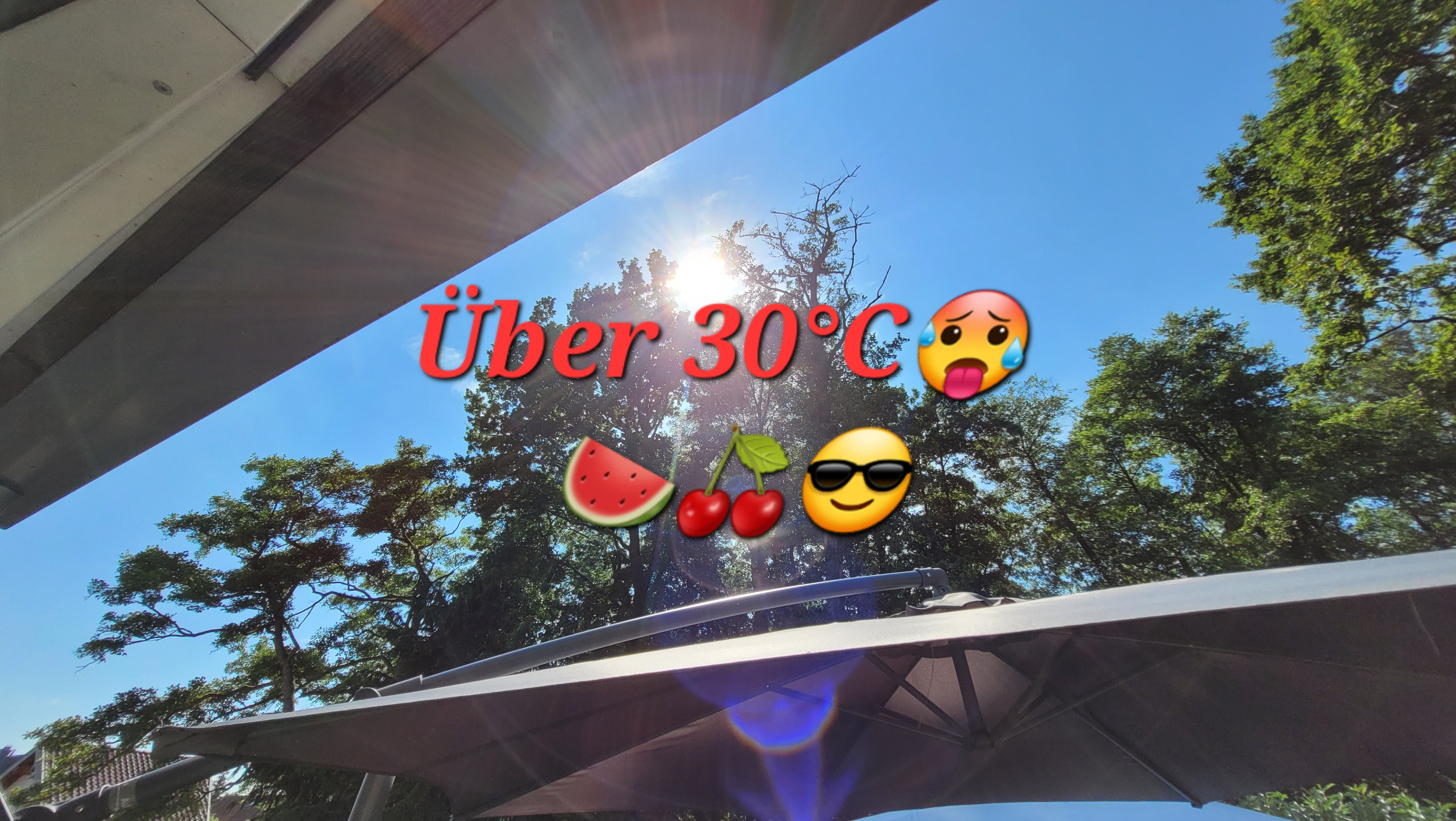 Sonniger Sommertag mit über 30 Grad Celsius, Sonnenschein, Sonnenschirm und Emojis für Hitze, Wassermelone, Kirschen und Sonnenbrille