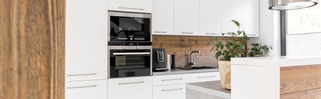 Moderne Küche mit schönen Küchenfronten in Freiburg, weiße Schränke und Holzrückwand