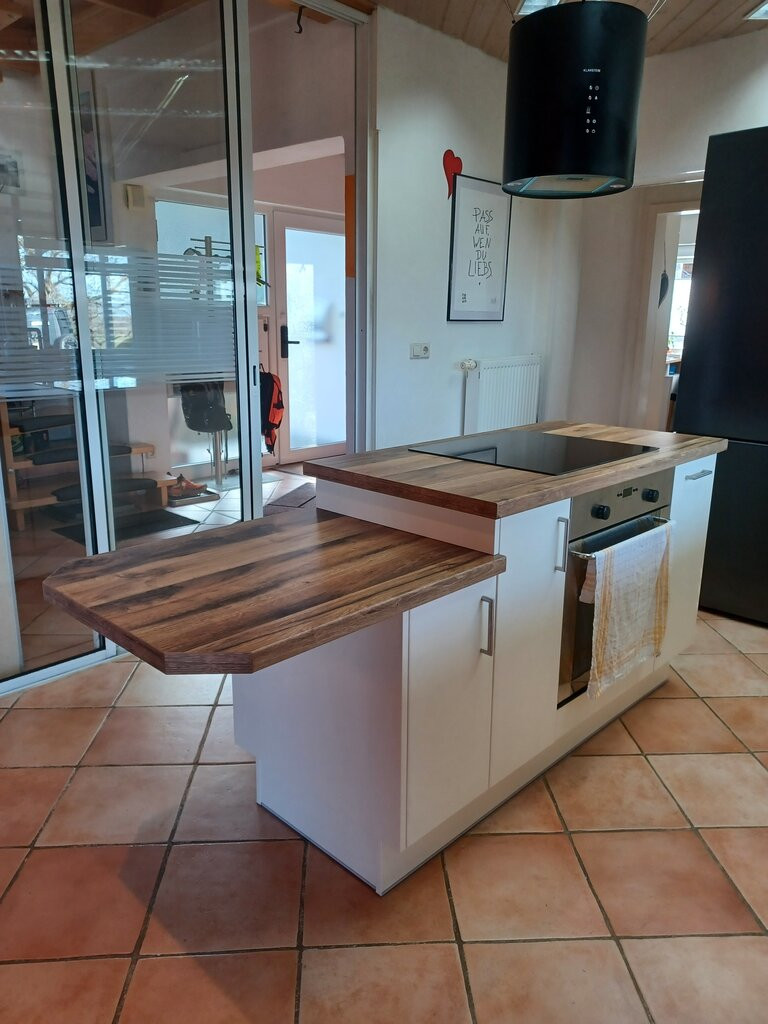 Moderne Küche nach der Modernisierung in Freiburg mit Kochinsel und Holzarbeitsplatte
