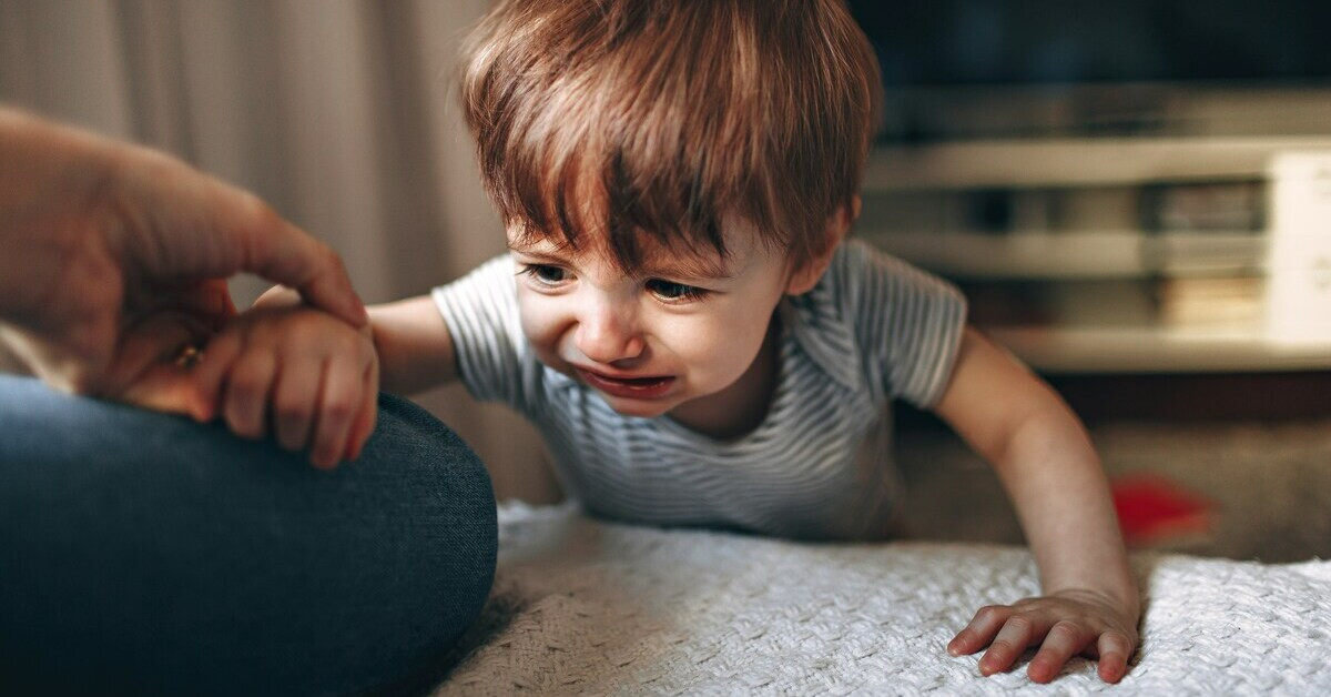 Weinender Junge hält die Hand eines Erwachsenen Junge weint und hält die Hand eines Erwachsenen
